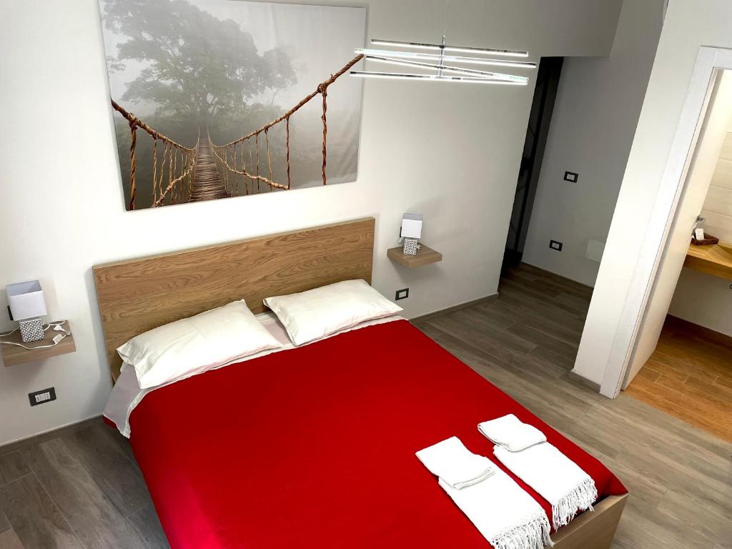 sypialnia z czerwonym łóżkiem i obrazem mostowym na ścianie w obiekcie incantevole casa vacanze con parcheggio w Pizie
