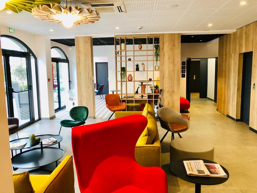 a lobby with yellow and red chairs and tables at ibis Beaune Centre in Beaune