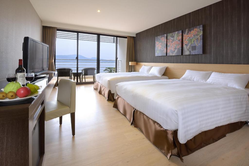 um quarto de hotel com duas camas e uma televisão em Lealea Garden Hotels - Sun Lake em Yuchi