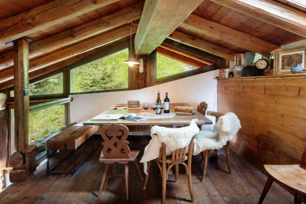 een eetkamer met een tafel en stoelen in een hut bij HelloChalet - Chalet da MiRo - Sunny terraces with stunning Matterhorn views, reachable on foot only in Valtournenche