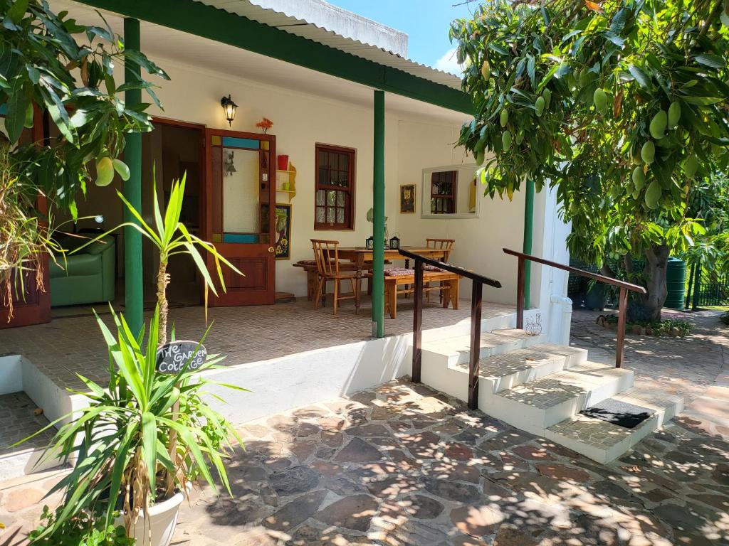 a house with a patio with a table and chairs at Rosenhof Garden Cottage in Clanwilliam