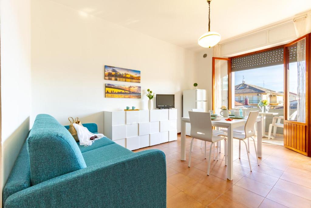 ein Wohnzimmer mit einem blauen Sofa und einem Tisch in der Unterkunft Appartamento Alba Rosa 5 - MyHo Casa in Alba Adriatica
