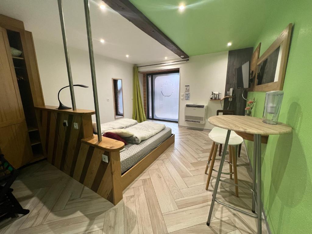Habitación con cama, escritorio y mesa. en Le Domaine du Verger, Chambres d'Hotes, en Osenbach