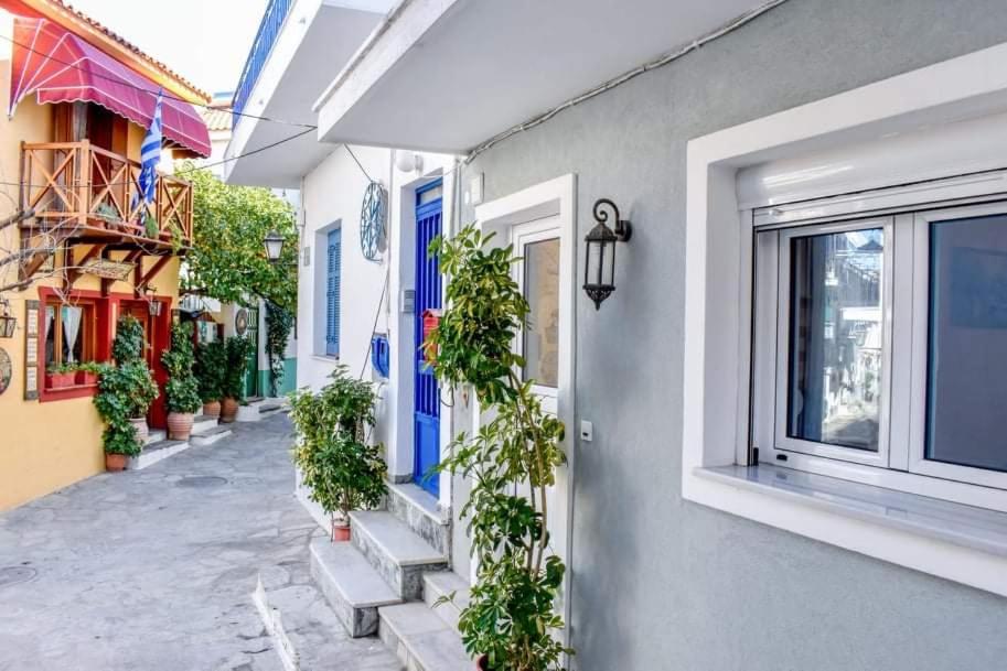 een gebouw met blauwe deuren en potplanten bij Klaidis house in Skiathos-stad