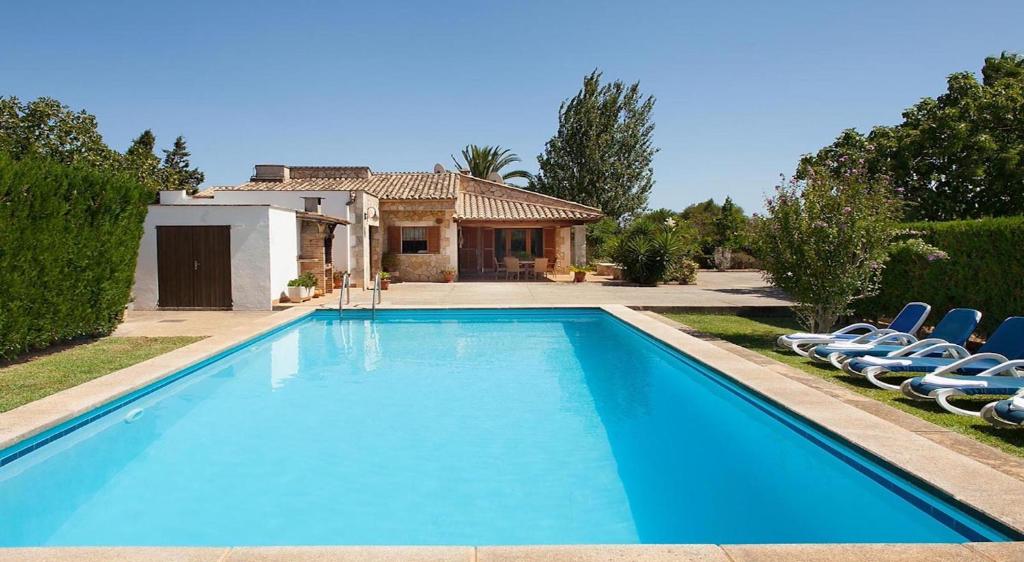 una piscina con sillas frente a una casa en Villa Magraner Catalina, en Pollensa