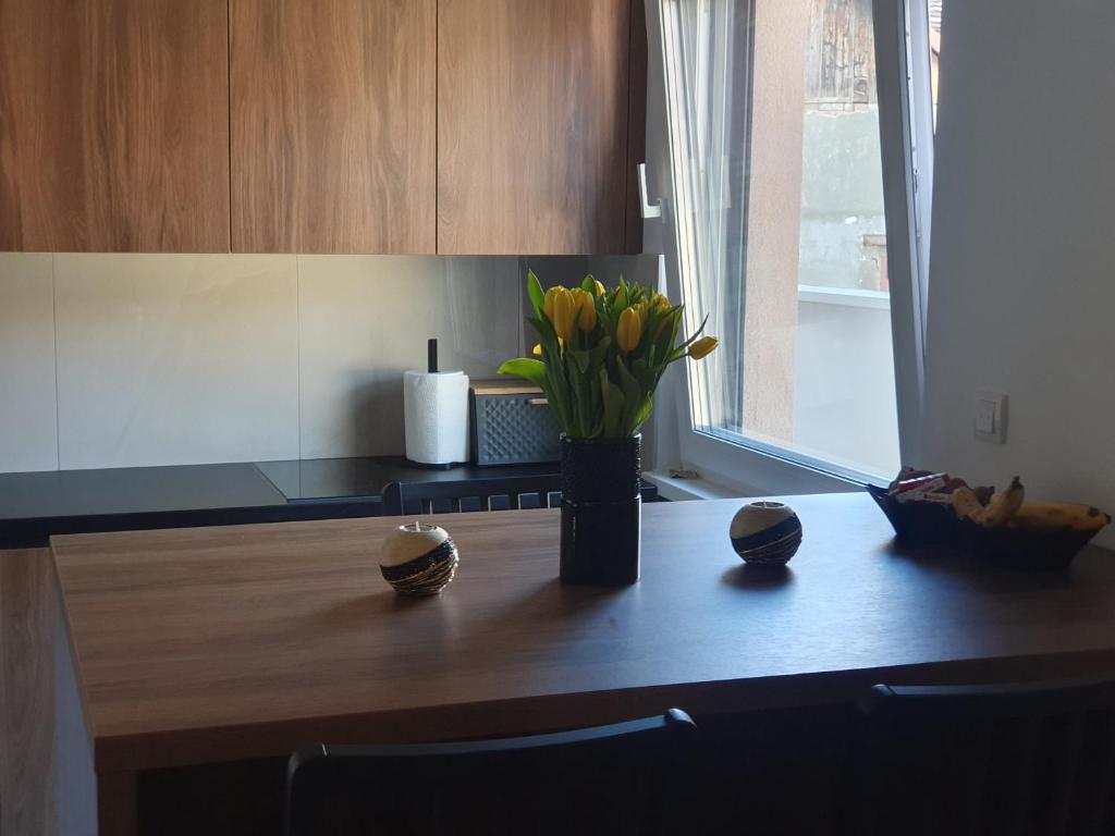 a kitchen counter with a vase of flowers on a table at Proximus in Sremska Mitrovica