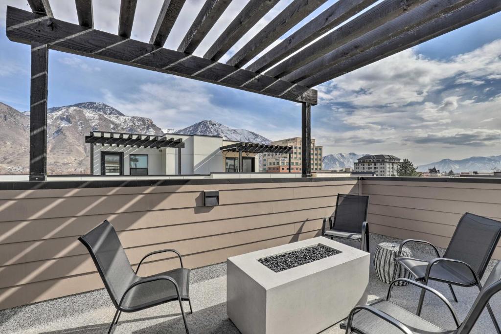 eine Terrasse mit Stühlen und einem Tisch auf dem Dach in der Unterkunft Chic and Sunny Provo Townhome with Rooftop Deck! in Provo