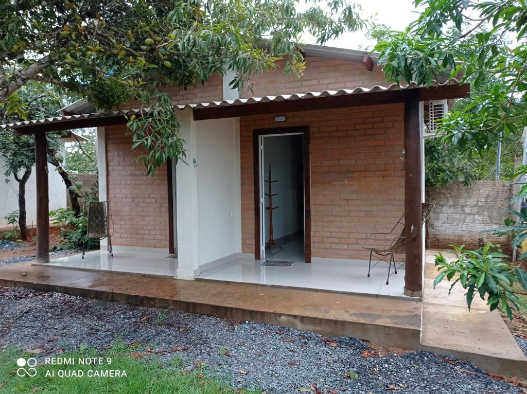 una piccola casa di mattoni con una porta nera di Casa Stúdio Uirá - suíte a Chapada dos Guimarães