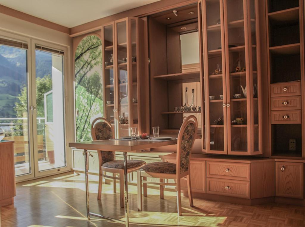 a dining room with a wooden table and chairs at Studio-Appartement Drei Hörndl in Bad Hofgastein