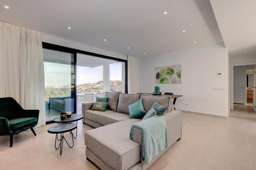 a living room with a couch and a chair at 085 Modern Apartment in Trendy La Cala Golf Resort in Málaga