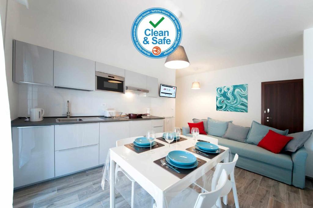 een keuken en een woonkamer met een tafel en een bank bij Cipriani 5 RivieraHoliday in Pietra Ligure