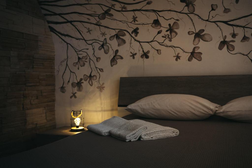 a bedroom with a bed with a tree mural on the wall at Dimora Santa Caterina in Altamura