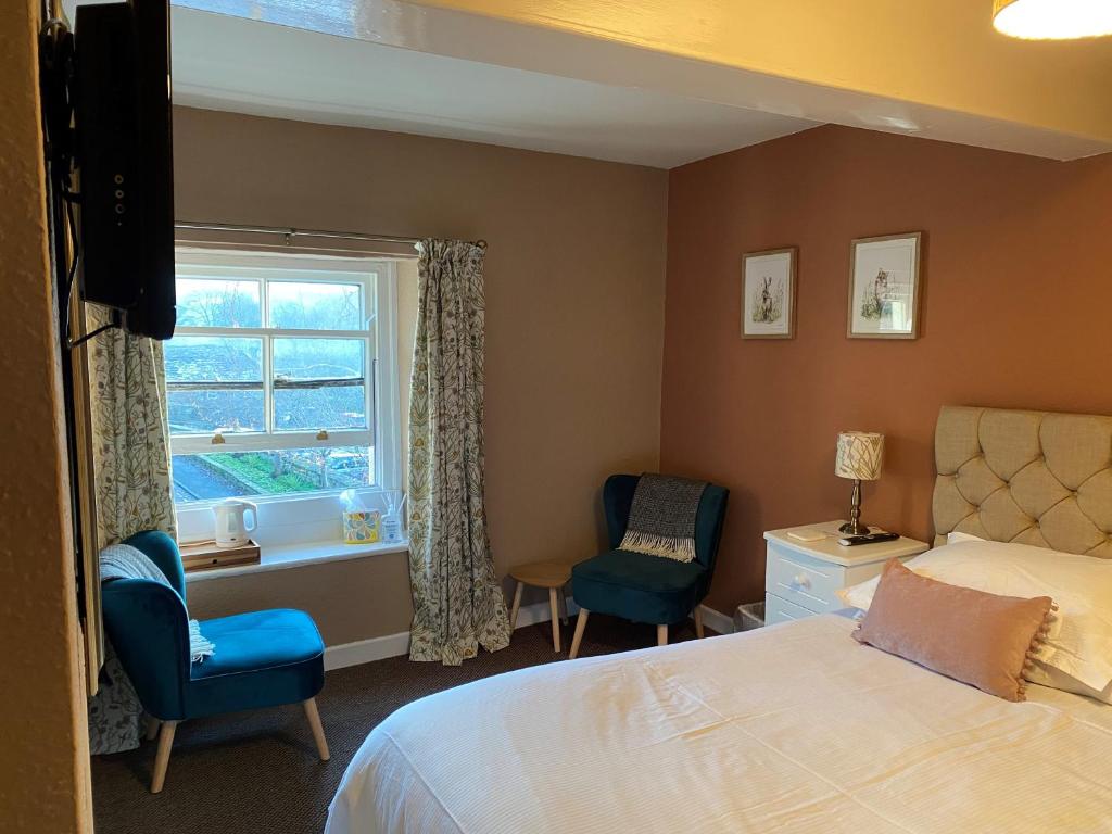 1 dormitorio con 1 cama, 2 sillas y ventana en Talbot House Bed & Breakfast and Tearoom en Pateley Bridge