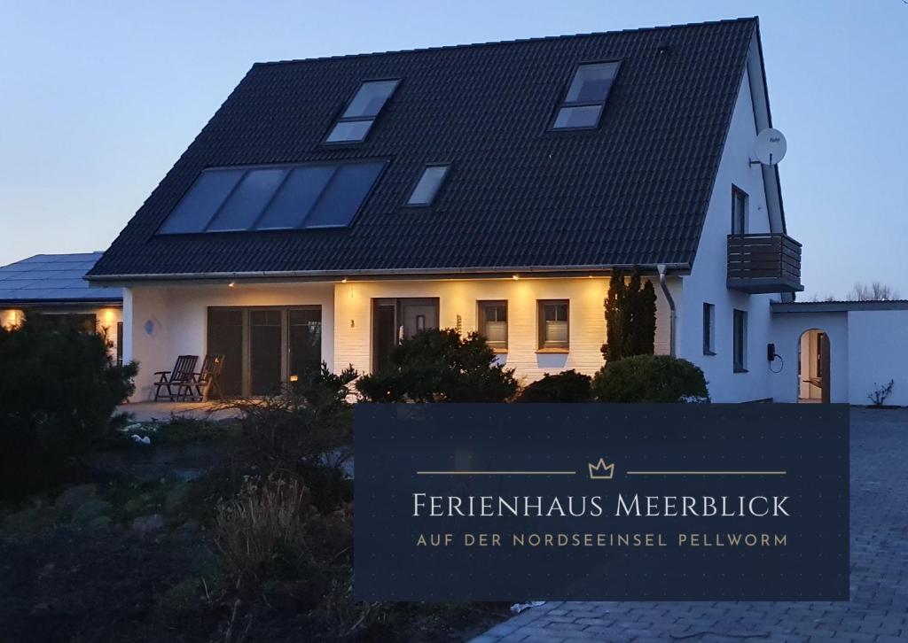 uma casa com um sinal em frente em Ferienhaus Meerblick em Pellworm