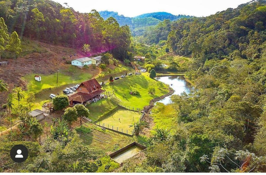 an aerial view of a house on a hill next to a river at Sitio Recanto da Preguiça in Santa Teresa