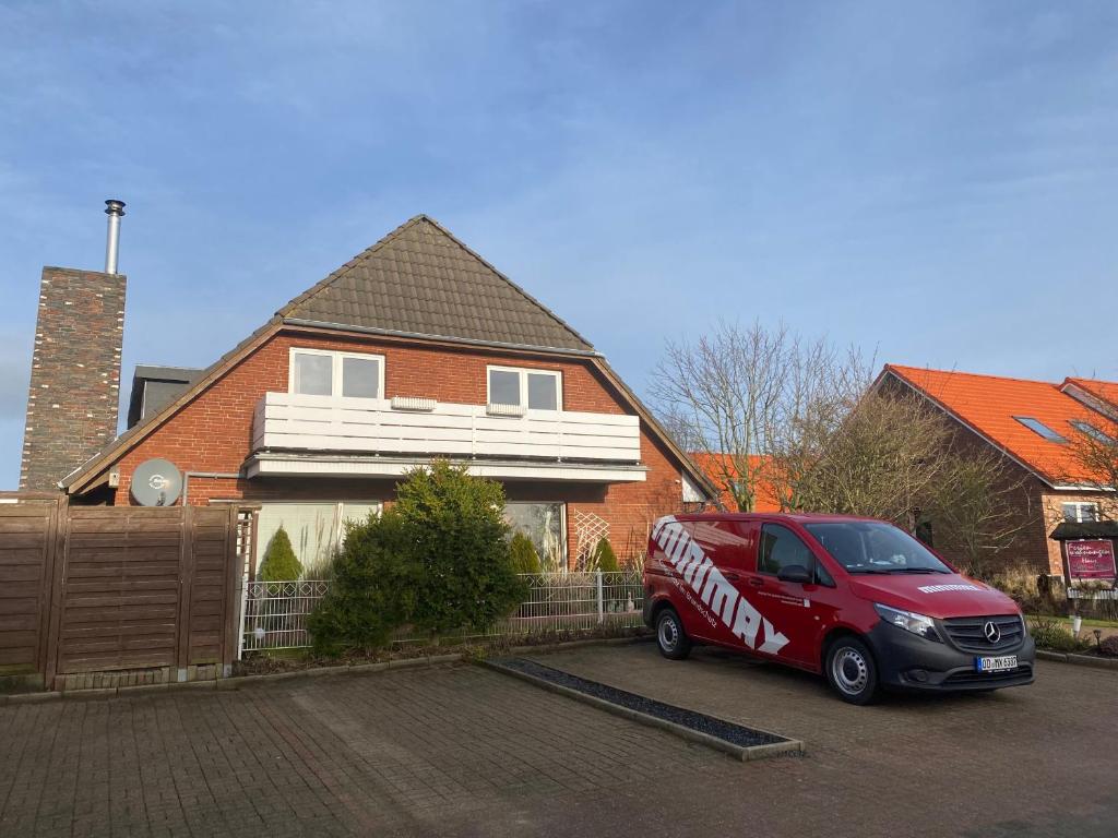 a red van parked in front of a house at Haus Ebbe und Flut Dagebüll in Dagebüll