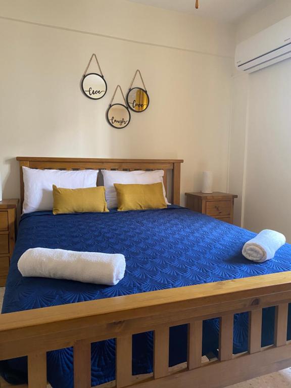 a bedroom with a blue bed with two pillows on it at Diamond Apartment with stunning sea view in Paphos City