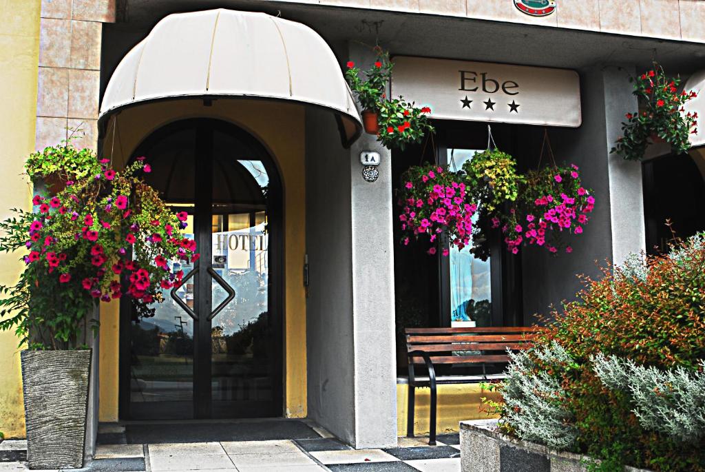 ein Gebäude mit einer Bank vor einem Gebäude mit Blumen in der Unterkunft Hotel Ebe in San Piero a Sieve