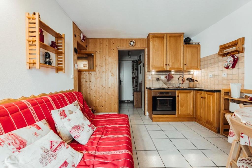 a living room with a red couch in a kitchen at Apartment with balconies ski-in ski-out classified 2 stars in Saint-Gervais-les-Bains