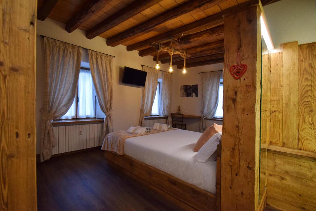 a bedroom with a bed and two windows at Affittacamere da Annarè in Candide