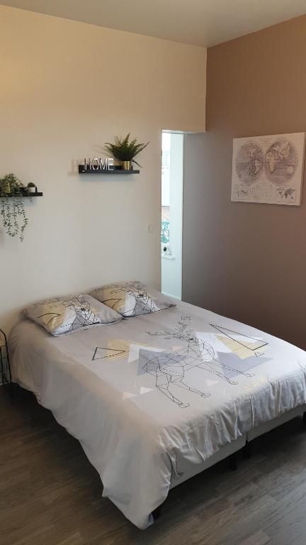 a bedroom with a large bed with a white sheet at Linotin centre ville Compiègne in Compiègne