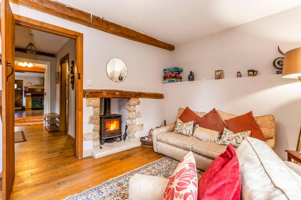 a living room with a couch and a fireplace at The Stables in Chipping Campden