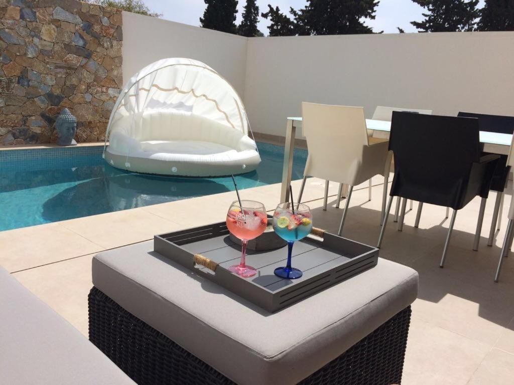 two glasses on a tray next to a swimming pool at Casa del Mar Menor in San Javier