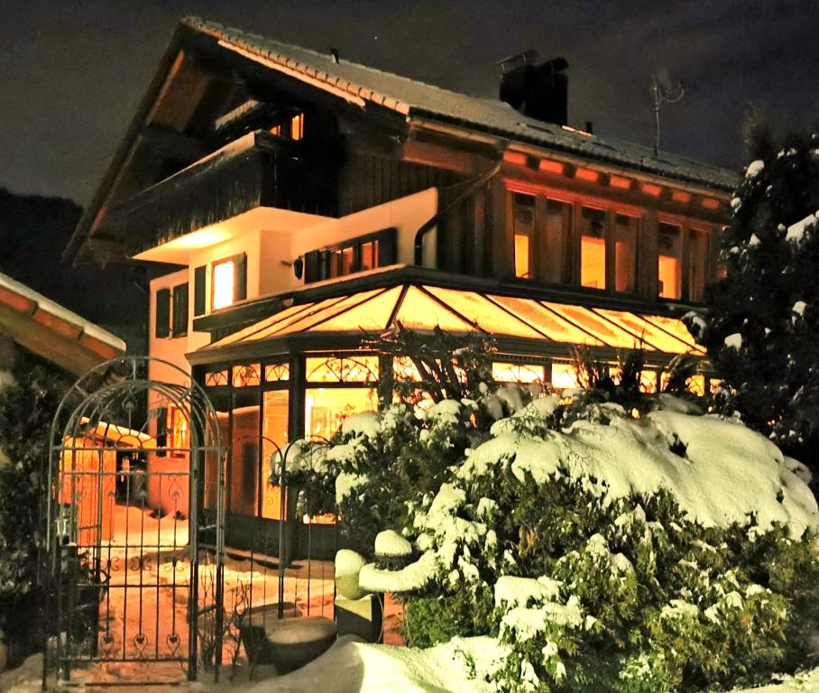 ein Haus mit Schnee auf dem Boden davor in der Unterkunft Konstanzer Bergblick mit Wintergarten in Oberstaufen