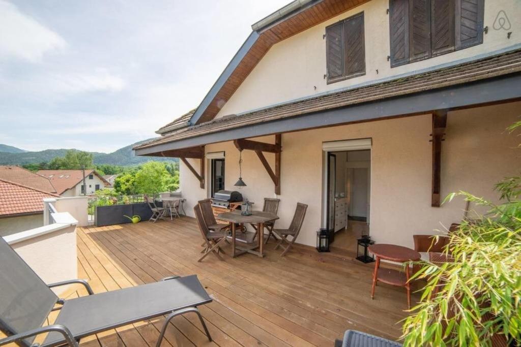 a wooden deck with a table and chairs on a house at Amélia Appartement Saint-Jorioz in Saint-Jorioz