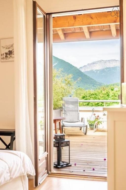 a bedroom with a door open to a balcony at Amélia Appartement Saint-Jorioz in Saint-Jorioz