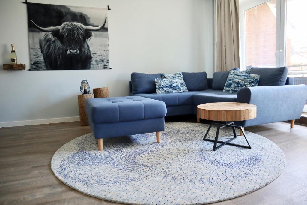 a living room with a blue couch and a table at Ferienwohnung Strandhafer - a64918 in Wittdün