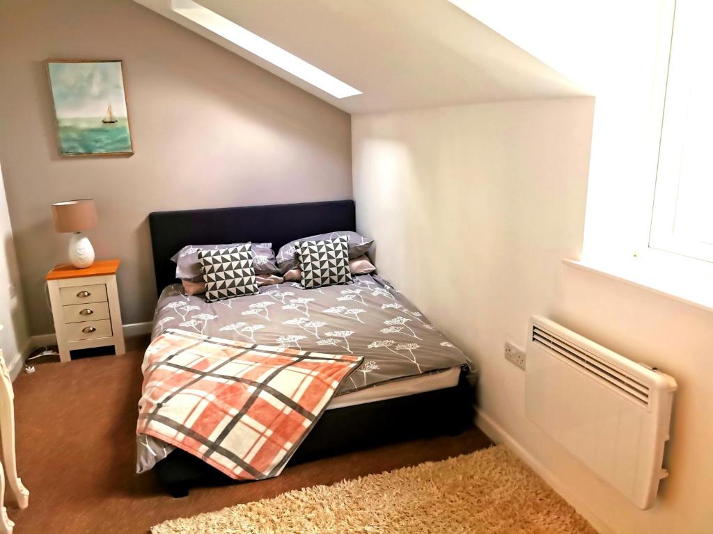 a bedroom with a bed with pillows on it at Sunflower Apartment, Family accommodation Near Tenby in Pembrokeshire in Tenby