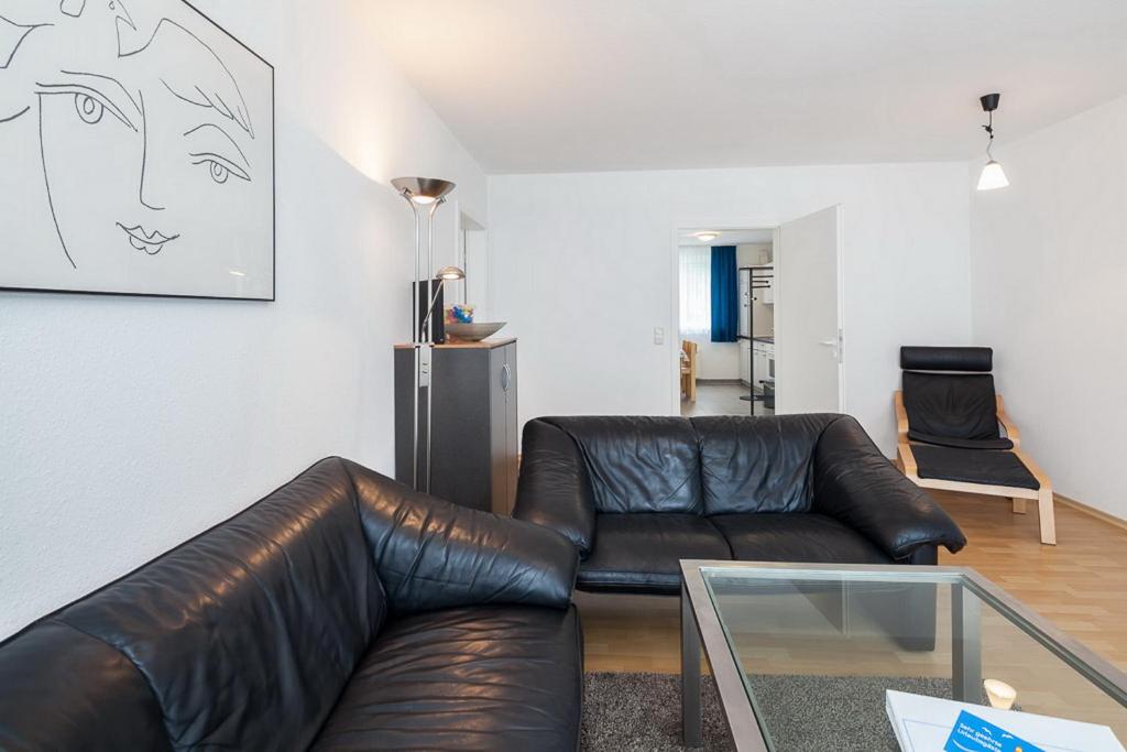 - un salon avec un canapé en cuir et une table en verre dans l'établissement Sünnslag Wohnung 087, à Boltenhagen