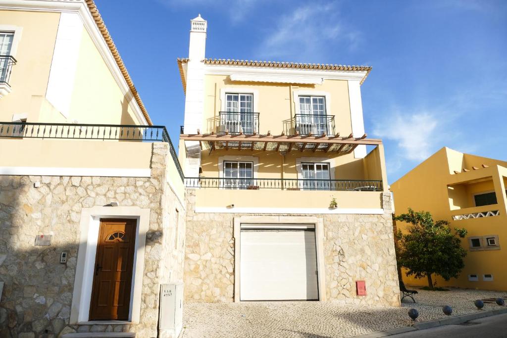 um grande edifício amarelo com uma porta e uma janela em Encosta das Oliveiras 49D em Vilamoura