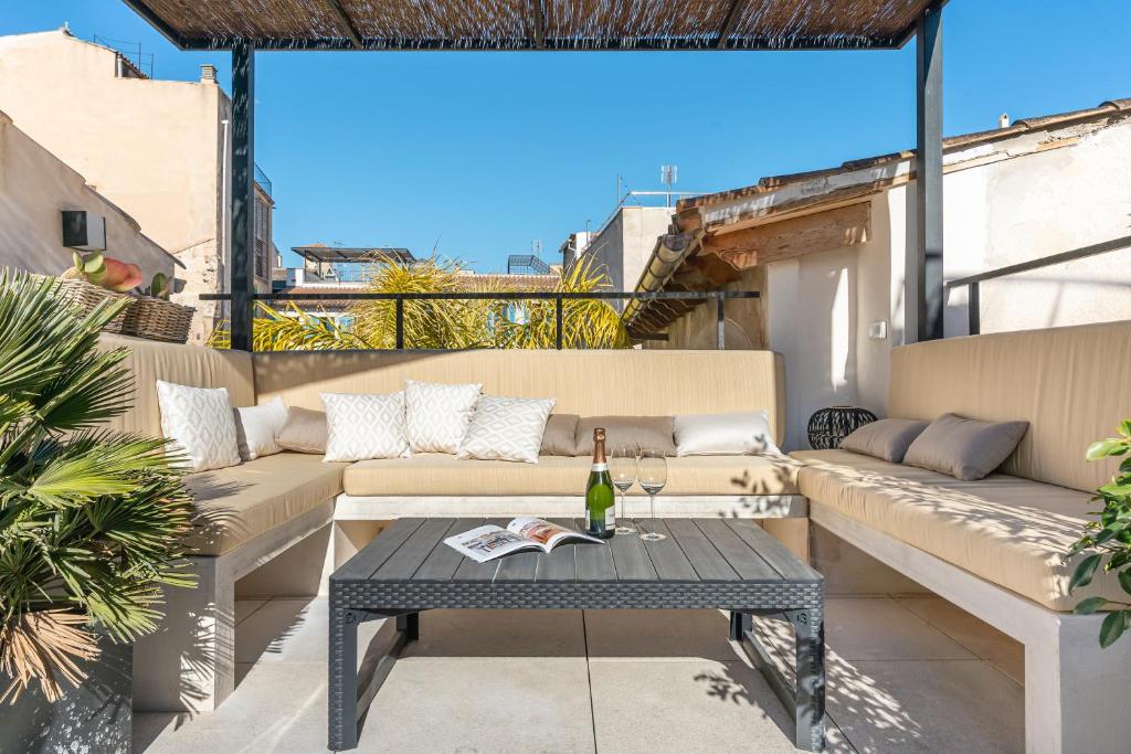 a patio with couches and a table with a bottle of wine at Townhouse Calatrava in Palma de Mallorca