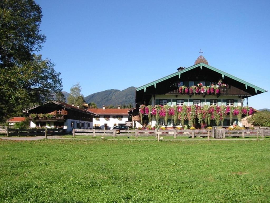 un edificio con flores en un campo en Familien-Bauernhof-Berghammer, en Rottach-Egern