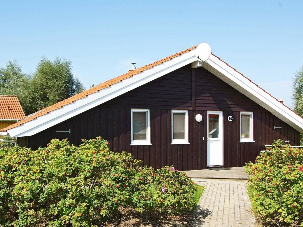 ein braunes Haus mit weißem Dach in der Unterkunft 6 person holiday home in Otterndorf in Otterndorf