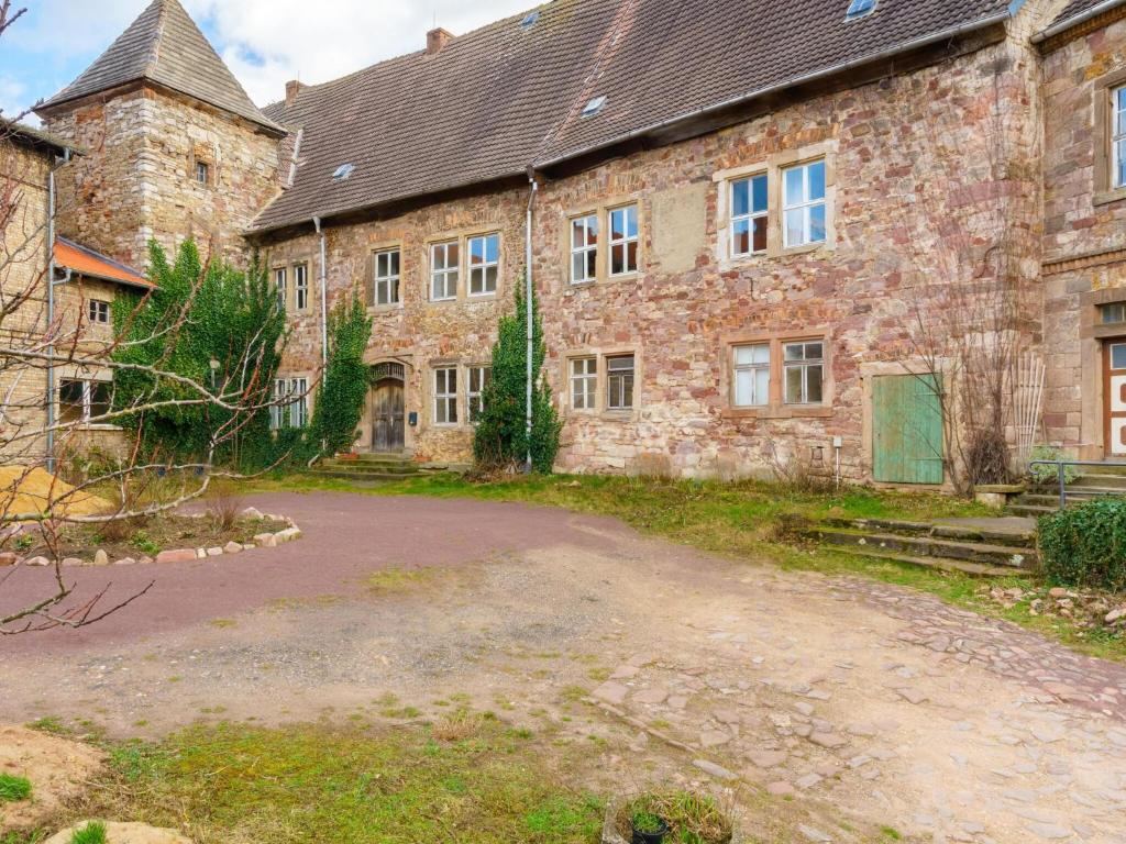 an old stone building with a driveway in front of it at Apartment in Gerbstedt Friedeburg with Terrace in Friedeburg