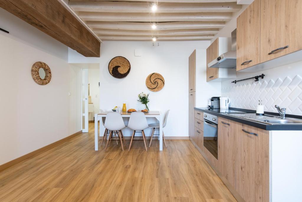 a kitchen and dining room with a table and chairs at Ambiance bohème in Roanne