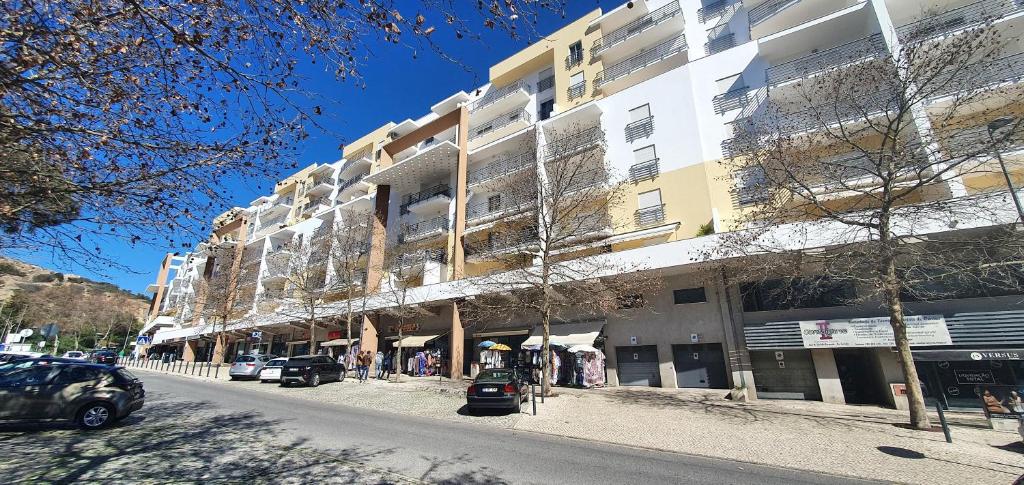 a building on a street with cars parked in front of it at Apartamento Dionisio in Albufeira