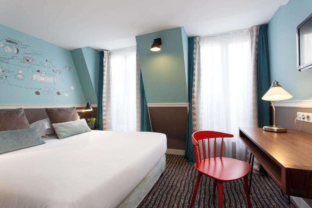 Pokój hotelowy z łóżkiem i biurkiem w obiekcie Hôtel des 3 Poussins w Paryżu