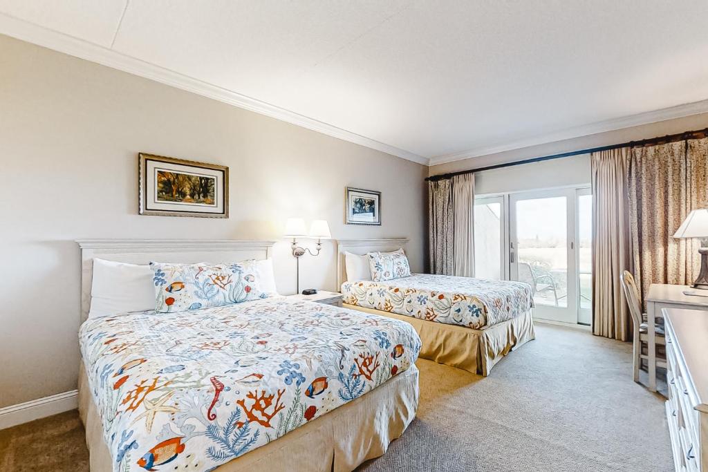 a hotel room with two beds and a balcony at 256 Sandcastles - Hotel Side in Fernandina Beach