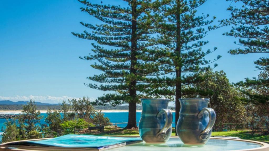 dos jarrones de cristal sentados sobre una mesa en Perfectly Positioned Beachfront Apartment - Unit 6 en Port Macquarie
