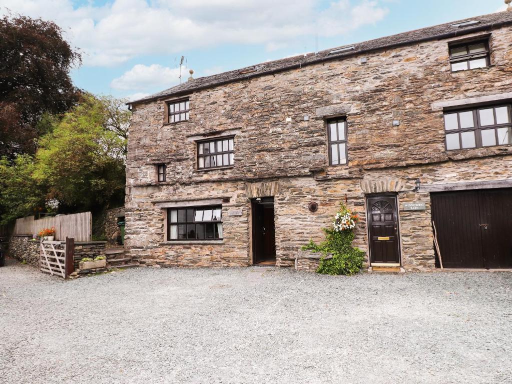 an old stone house with a driveway in front of it at Cherry Tree Cottage at Satterthwaite in Hawkshead