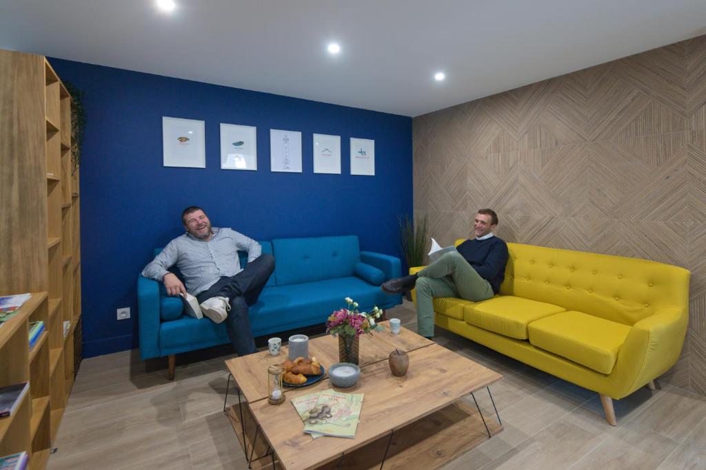 dois homens sentados em sofás numa sala de estar em Five to Sete em Sète