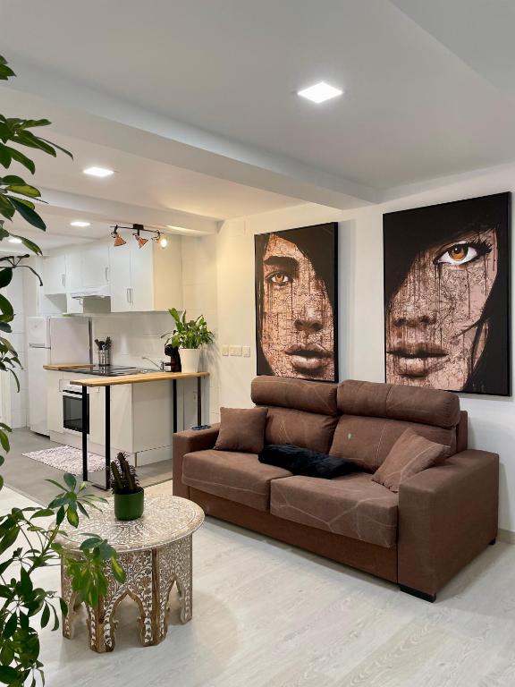 a living room with a brown couch and a kitchen at A Das Marías ESTUDIO in Ourense