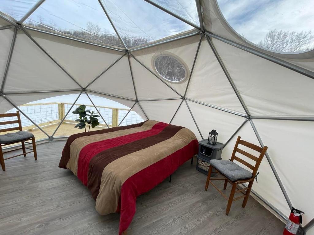 a bedroom in a yurt with a bed and two chairs at Laurel River Club Bed & Breakfast or LRCBNB in Dryfork