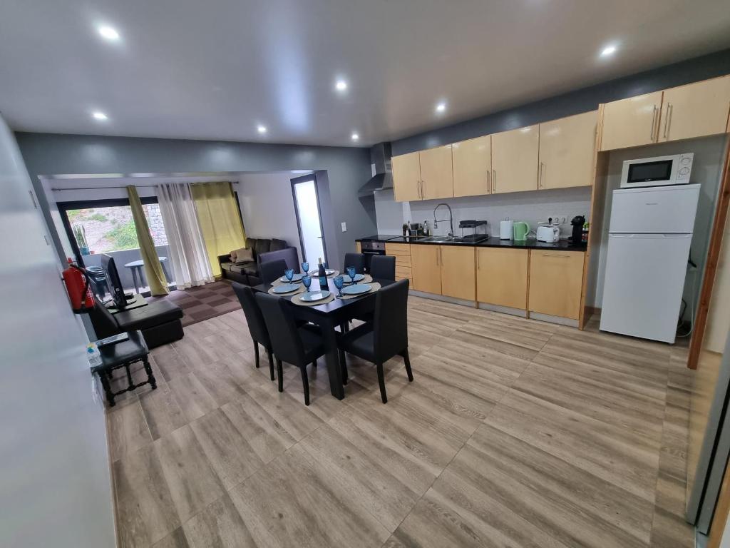 una sala da pranzo e una cucina con tavolo e sedie di Casa do João Bento a Água de Alto