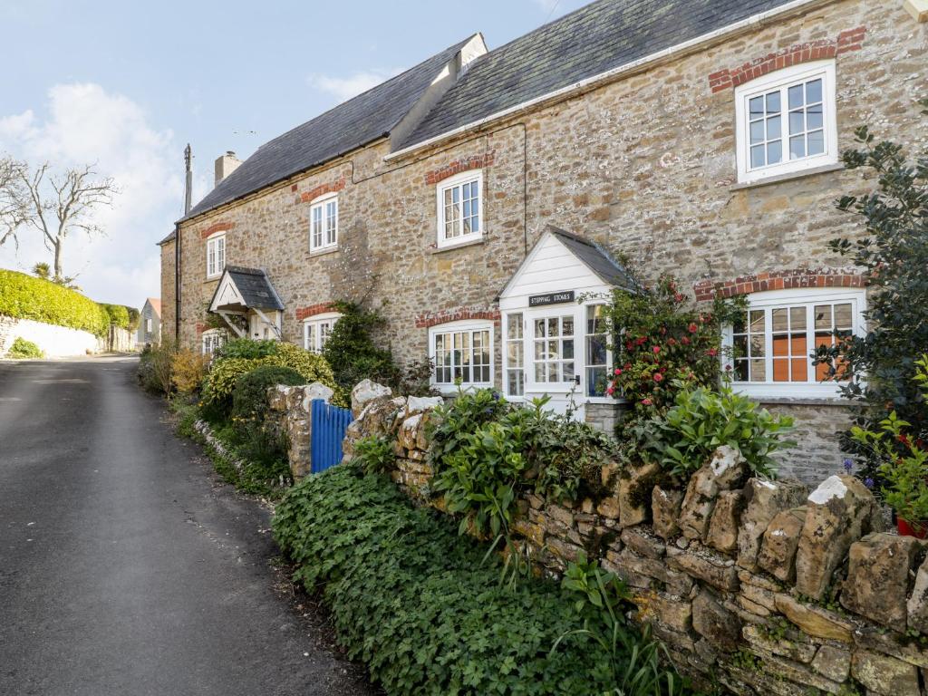 an old stone house with a stone wall at Stepping Stones in Weymouth