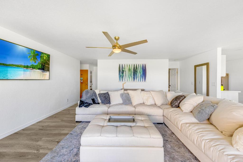 a living room with a white couch and a ceiling fan at Newly Renovated Condo Stand Up Paddle Boards Included! in Kailua-Kona
